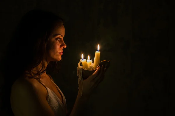 Uma rapariga a segurar uma vela de cera. Casa abandonada . — Fotografia de Stock