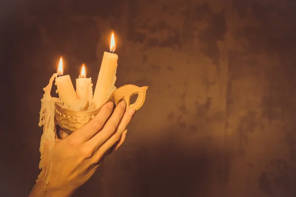 Mãos segurando uma vela de cera . — Fotografia de Stock