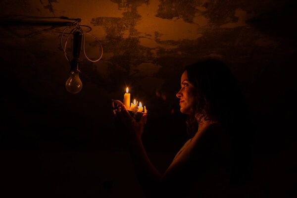 She shines a candle on a light bulb