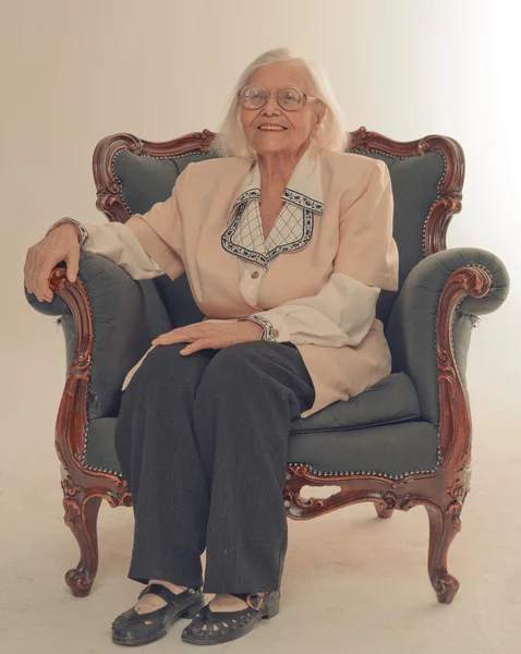 오래 된의 자에 앉아 하는 할머니 미소. — 스톡 사진