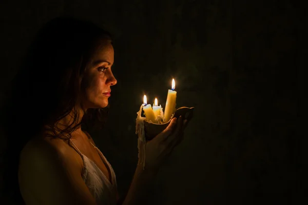 A girl holding a wax candle. Abandoned house. — Stock Photo, Image