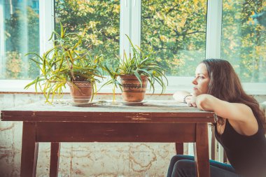 Ucuz konaklama. Eski masada oturan bir kız