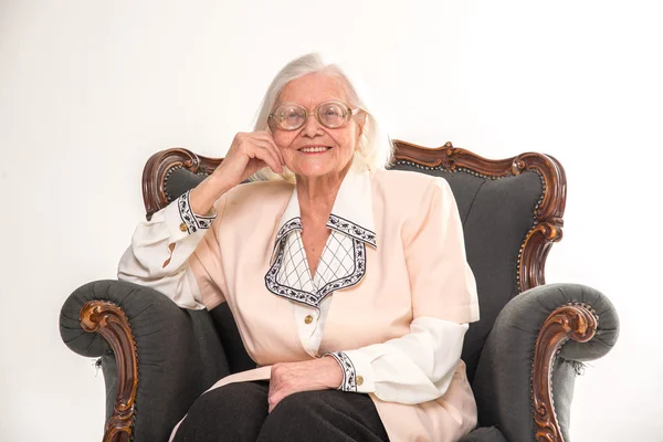 Nonna seduta su una vecchia sedia. Sorrisi . — Foto Stock