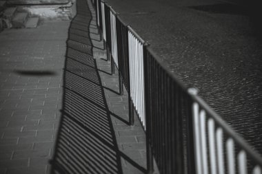 Metal çit. Çitin üzerine gölge düşer.