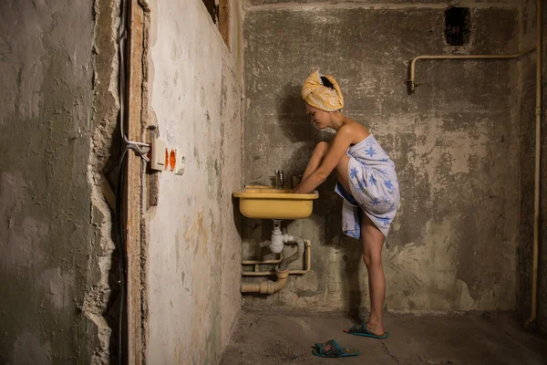 Cheap accommodation. The girl washing her feet in the sink — Stock Photo, Image