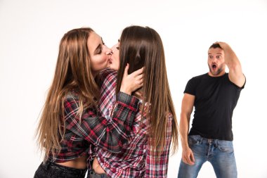 The girl kissing a girl. Man in shock. clipart