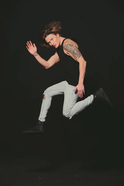 모델입니다. 검은 셔츠와 청바지 높은 점프에 남자. — 스톡 사진