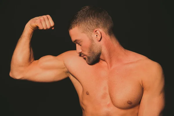 Modell. athletischer Typ mit nacktem Körper. der Kerl schaut auf seinen Muskel — Stockfoto