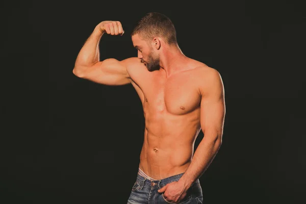 Un modello. Un atleta con un corpo nudo. Il tipo guarda la sua muscolatura — Foto Stock