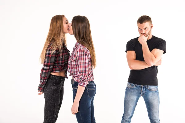 Das Mädchen küsst ein Mädchen. Mann unter Schock. — Stockfoto