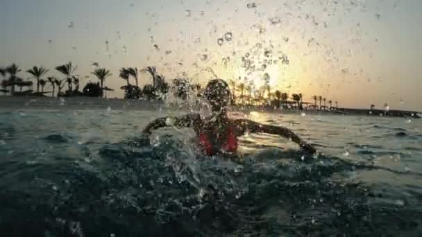 在日落的背景下 女人在海里游泳 — 图库视频影像