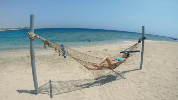 ハンモック ひとりの女性が海辺のハンモックに腰を下ろしている エジプトだ — ストック動画