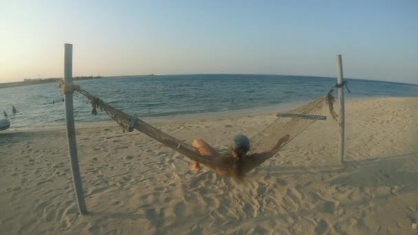 ハンモック 無人のビーチでハンモックに寝そべっている男 エジプトだ — ストック動画
