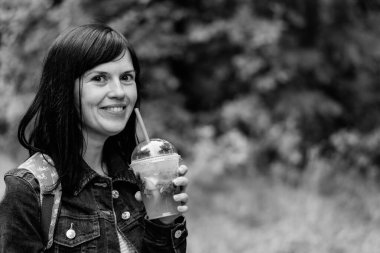 İçelim. Kız plastik bir tüple plastik bardaktan su içiyor..