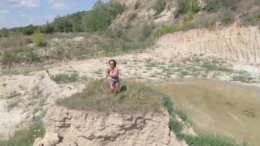 Spor. Spor yapan bir kız kumlu bir dağda egzersiz yapıyor. Hava görünümü.