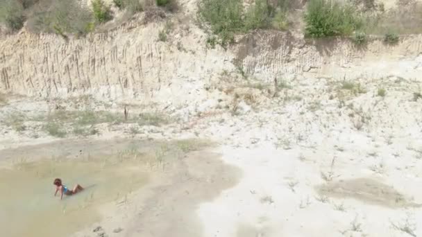 Zonnebaden Een Vrouw Een Badpak Zwemt Een Plas Midden Woestijn — Stockvideo