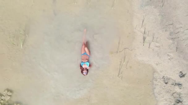 Zonnebaden Een Vrouw Een Badpak Zwemt Een Plas Midden Woestijn — Stockvideo