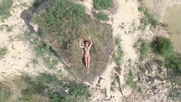 Zonnebaden Een Vrouw Een Badpak Zonnebaden Een Zandberg Het Midden — Stockvideo