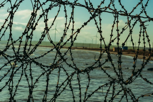 Barbed wire. Barbed wire fence near the sea.