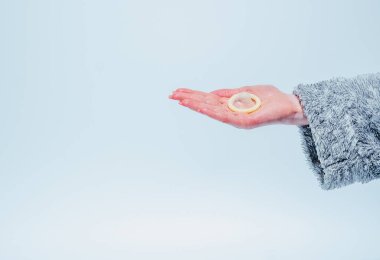 Prezervatif. Kadın eli lastik prezervatif gösterir..