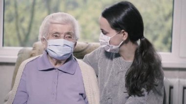 Dünya çapında bir salgın. Büyükanne ve torun tıbbi maske takıyor..