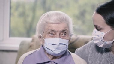 Dünya çapında bir salgın. Büyükanne ve torun tıbbi maske takıyor..