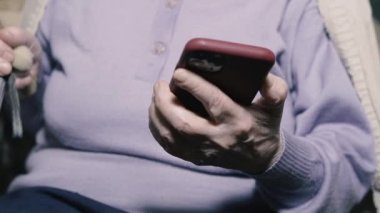 Cep telefonu. Yaşlı bir büyükanne modern bir cep telefonuyla konuşuyor..