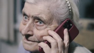 Cep telefonu. Yaşlı bir büyükanne modern bir cep telefonuyla konuşuyor..