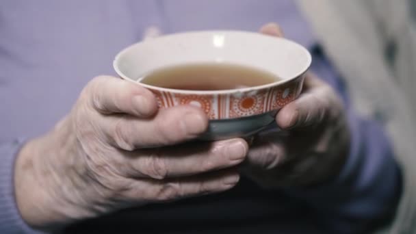 おばあちゃんがソーサーからお茶を飲んでる — ストック動画