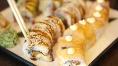 Yiyecekler. Suşi, yılan balığı ve kırmızı balıkla yuvarlanır. Yakın plan..