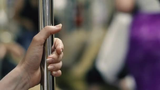 Geländer. Die Hand einer Frau an einem Geländer in öffentlichen Verkehrsmitteln.