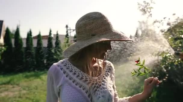 Cobertura Uma Mulher Chapéu Olha Para Uma Flor — Vídeo de Stock