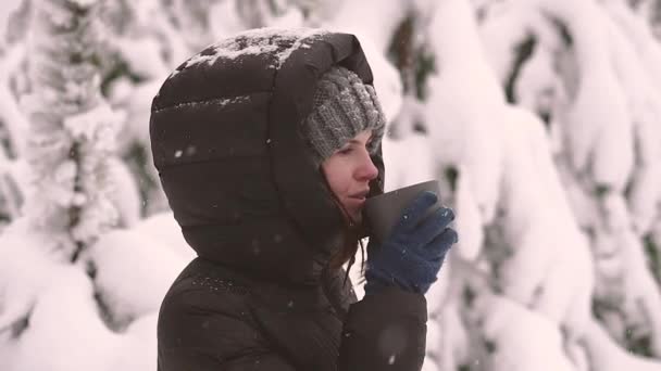 눈덮인 속의한 여자가 뜨거운 음료를 마시고 — 비디오