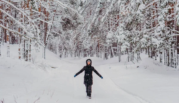 Kış. Karlı bir ormanın arka planında ceketli ve şapkalı bir kadın..