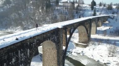 Viyadük köprüsü. Bir adam eski bir köprü boyunca yürür. Hava görünümü.