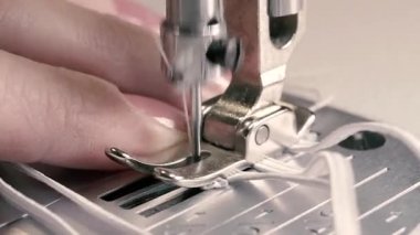 Dikiş makinesi. Dikiş makinesindeki iğne kumaşı dikiyor. Yakın plan..