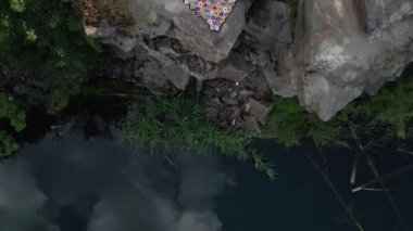 Kariyer. Kadın gölün yanındaki granit bir kayanın üzerinde yatıyor. Hava görünümü.