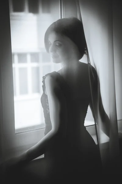 Uma rapariga olha pela janela — Fotografia de Stock