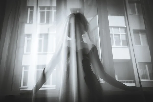 Uma rapariga olha pela janela — Fotografia de Stock