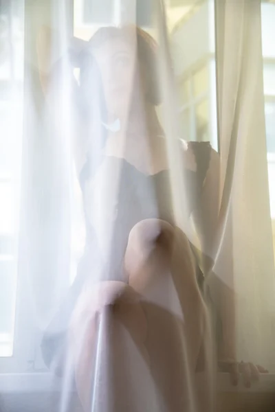 Una ragazza guarda fuori dalla finestra — Foto Stock