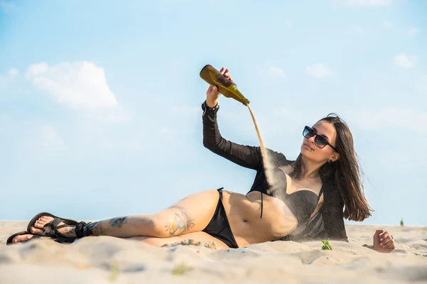 Das Mädchen ist in der Wüste und Sand strömt aus der Flasche — Stockfoto