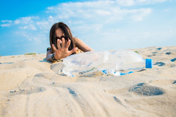 Девушка протягивает руку к бутылке с водой
