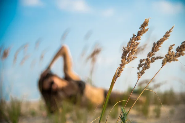 Das Mädchen liegt auf einem Hintergrund aus Weizenähren — Stockfoto