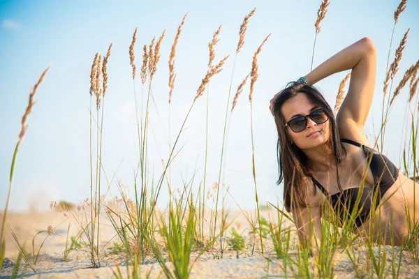 The girl lies on a background of wheat ears — Stock Photo, Image