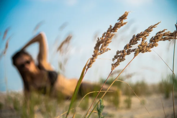 Девушка лежит на фоне колосьев пшеницы — стоковое фото