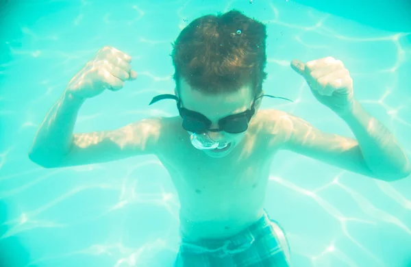 A boy shows the muscles under water on a hand — Stock Photo, Image