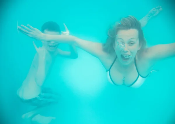 Madre e hijo hacen muecas bajo el agua en la piscina — Foto de Stock