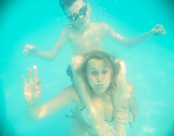 Madre e hijo hacen muecas bajo el agua en la piscina — Foto de Stock