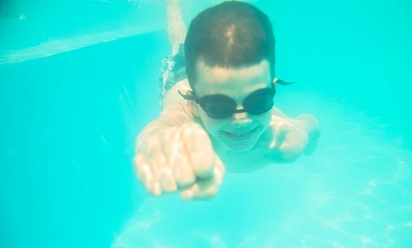 Een kleine jongen onderwater zwemmen in het zwembad — Stockfoto