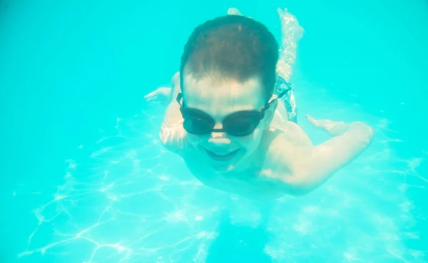 Un petit garçon nageant sous l'eau dans la piscine — Photo